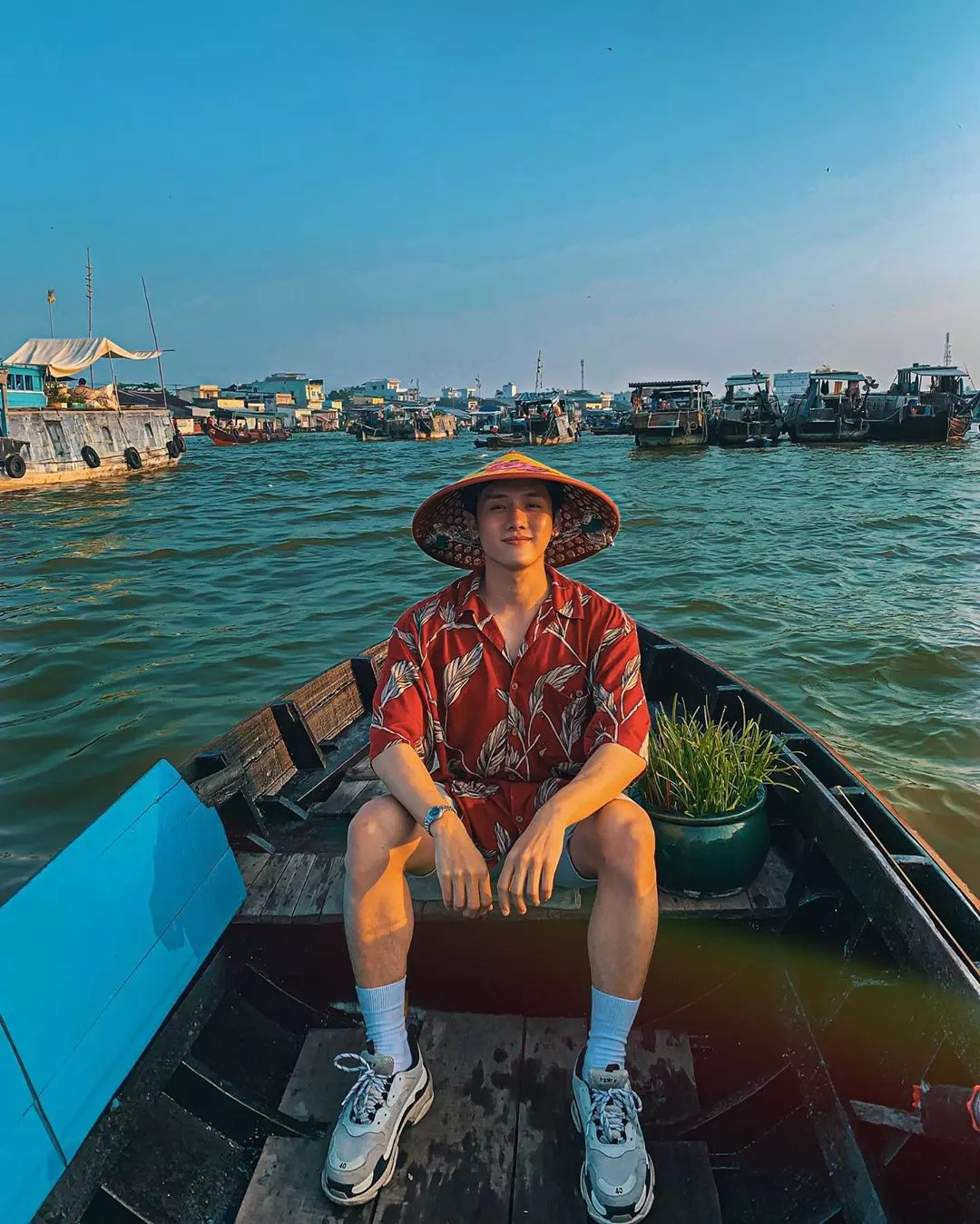 chàng trai chụp ảnh ngồi thuyền tại cần thơ