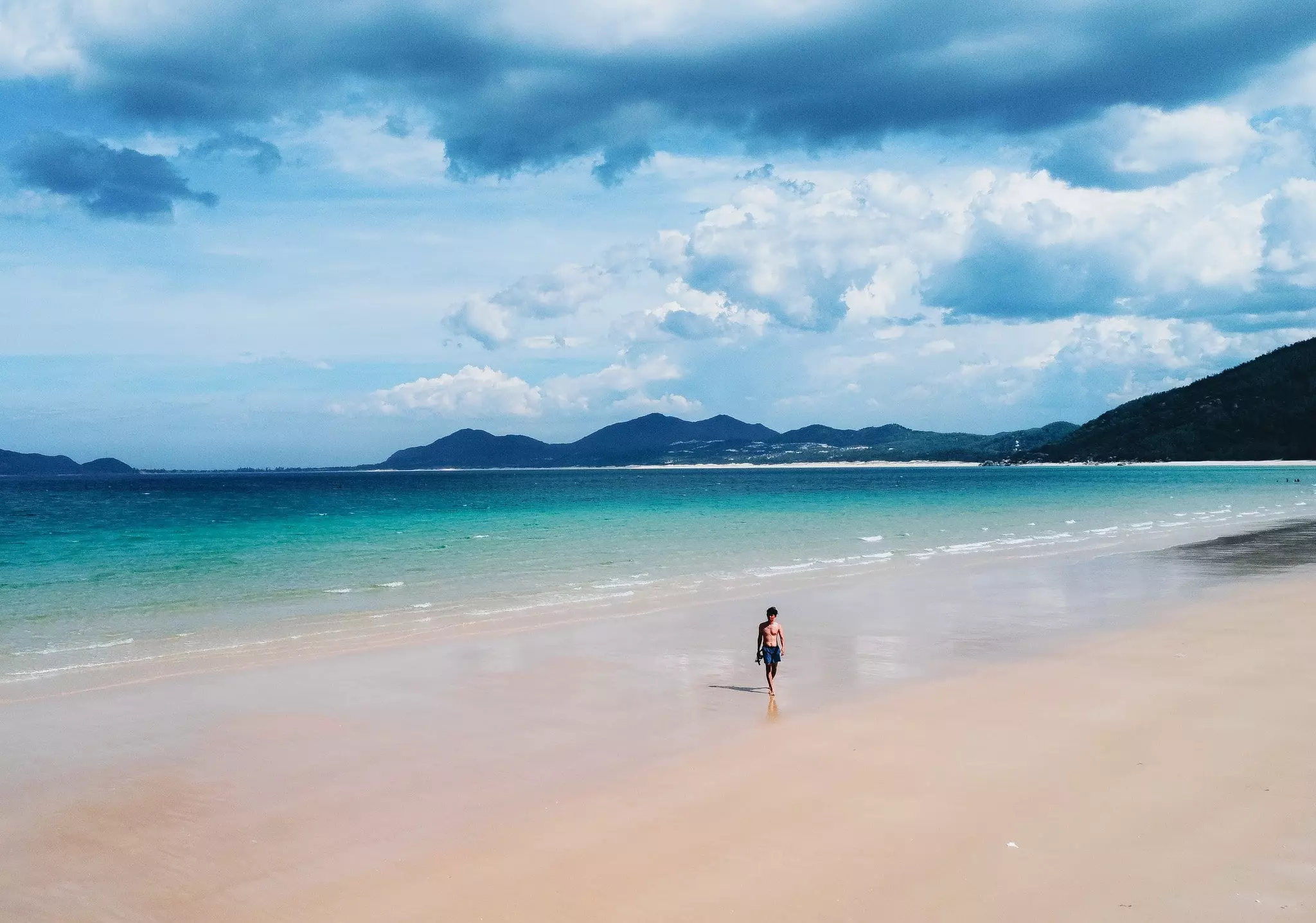 chàng trai đi bộ trên bãi biển vịnh hòa