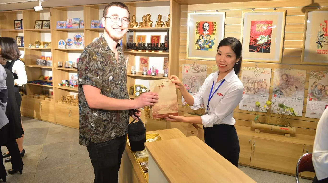 nhân viên cửa hàng gift shop chụp cùng du khách